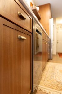 "Contemporary kitchen featuring custom brown cabinetry and organized shelves."