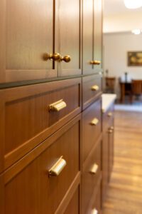 "Modern kitchen with brown cabinets, custom-built shelves, and stylish hardware."