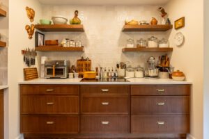 "Custom kitchen storage solutions with brown cabinets and open shelving."