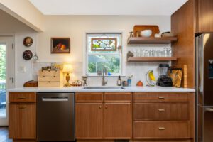 "Wall-mounted shelves in a kitchen with beautifully crafted brown cabinets."