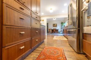 "Brown-toned kitchen cabinets with custom storage solutions and sleek handles."